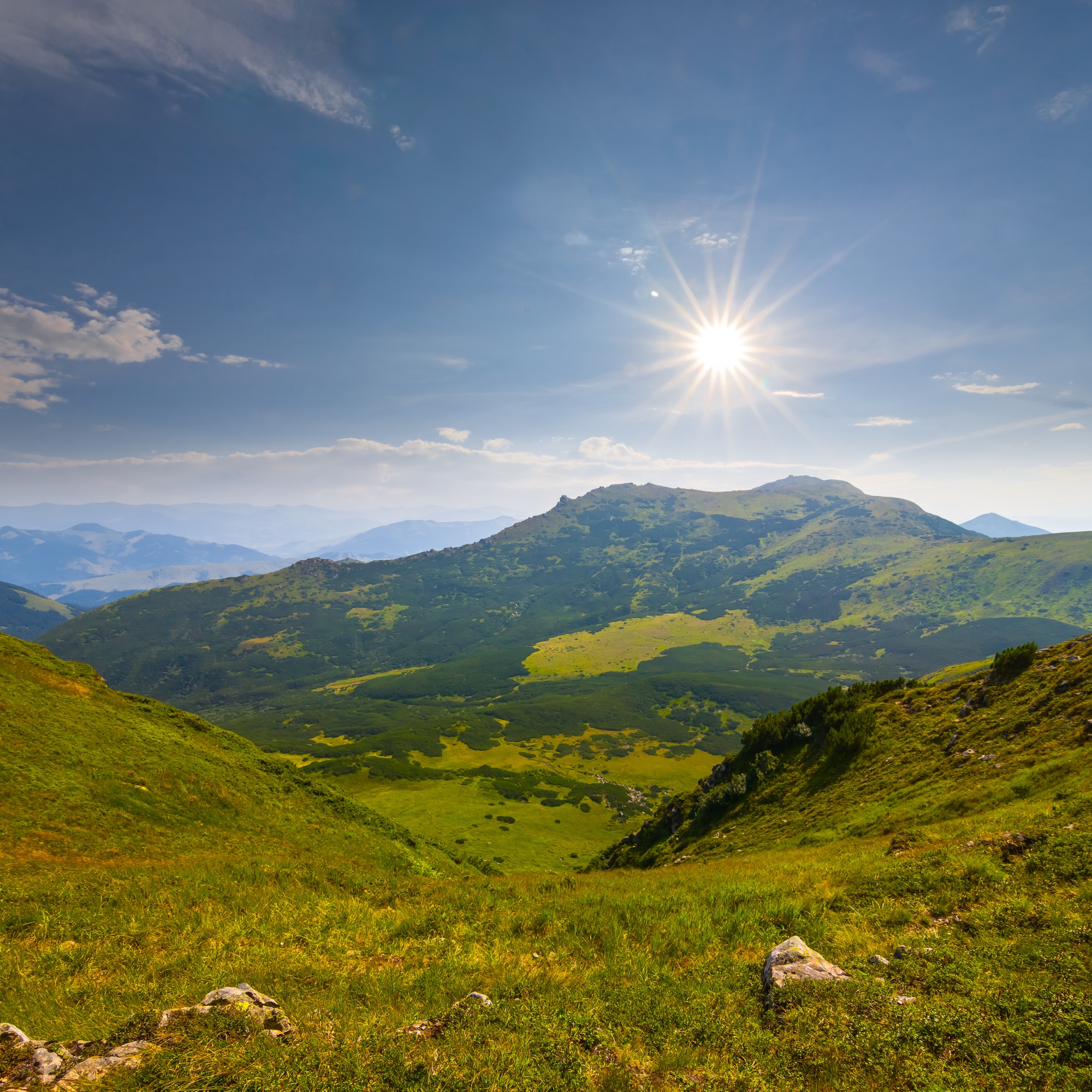 The sun above a mountain, and blue sky